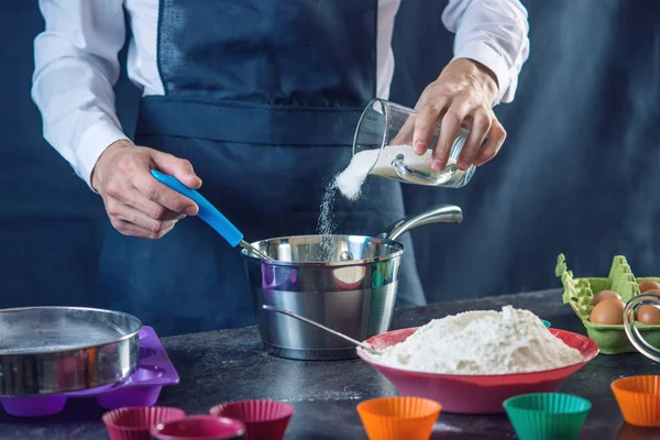 Pastelería Chef Delantal Negro Proceso Hacer Cupcakes Ingredientes Sobre Fondo — Foto de Stock