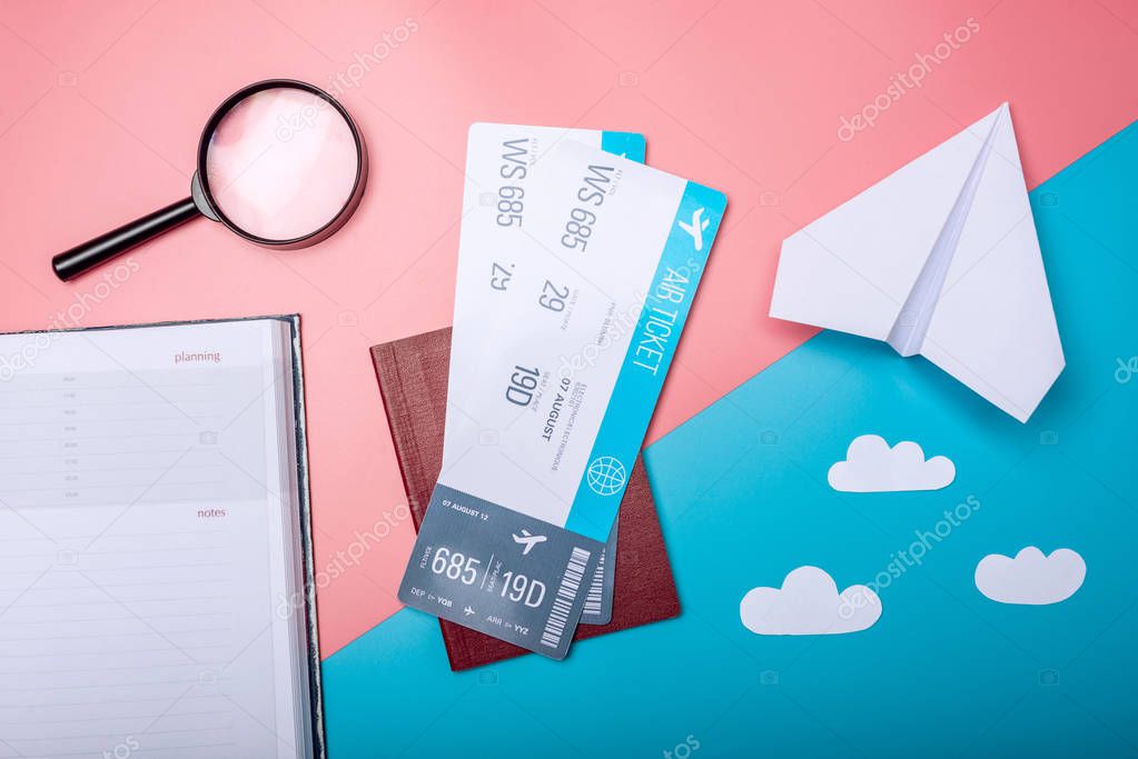 Air tickets with passport and paper plane on pastel background, topview. Bright background. The concept of air travel and holidays