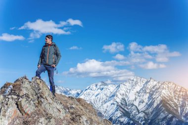 Adam uzun yürüyüşe çıkan kimse üstte duruyor ve gökyüzü ve karlı dağlarda güneşli havalarda bakar. Seyahat ve hedefe ulaşmak