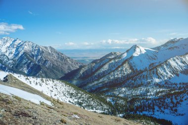 Güneşli havalarda rocky dağlarının karla kaplı tepeler manzara. Doğa ve seyahat kavramı