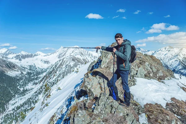 晴れた日の峰の麓で雪の山にトレッキング ポールが男性ハイカーが立っています 概念は旅行し 目標を達成します — ストック写真