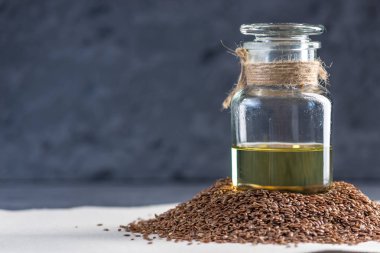 Bir yığın ve keten tohumu Keten tohumu altın yağda bir cam şişe masanın üzerinde. Omega 3 yağ asitleri ile kavram sağlıklı beslenme.