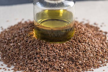 Bir yığın ve keten tohumu Keten tohumu altın yağda bir cam şişe masanın üzerinde. Omega 3 yağ asitleri ile kavram sağlıklı beslenme.