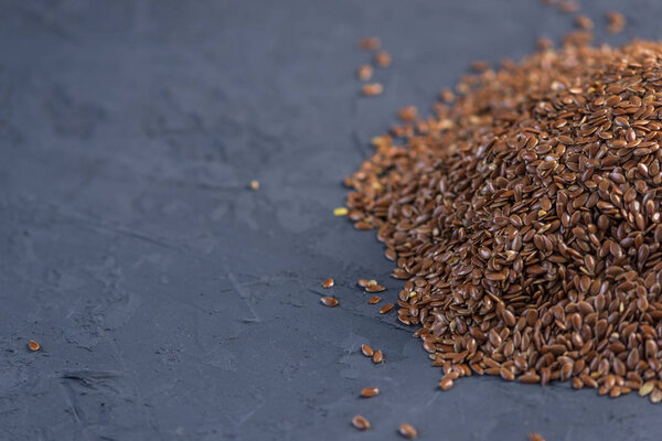 Flax seeds in a pile on a dark background. Top view. Concept healthy diet with omega 3 fatty acids.