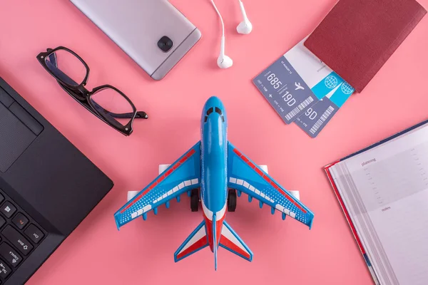 비행기 항공권 노트북 핑크색 바탕에 헤드폰으로 정상에서 전망입니다 준비의 — 스톡 사진