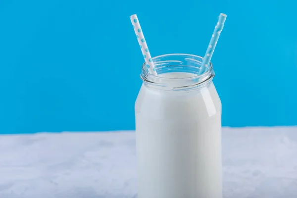 Botella Vidrio Leche Fresca Con Dos Pajitas Sobre Fondo Azul — Foto de Stock