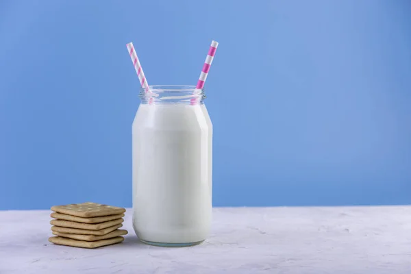 Skleněná Láhev Čerstvého Mléka Slámou Soubory Cookie Modrém Pozadí Barevný — Stock fotografie