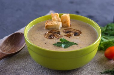 Kremalı mantar çorbası masanın üzerinde yeşil bir kasede. Koyu arka plan. Sağlıklı sonbahar vejetaryen geleneksel yemek