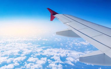 Uçak uçuş bulutlar bir arka plan üzerinde kanat. Seyahat ve yeni ülkeler için uçuşlar