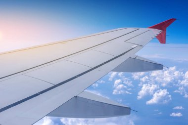 Uçak uçuş bulutlar bir arka plan üzerinde kanat. Seyahat ve yeni ülkeler için uçuşlar