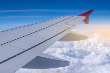 Uçak uçuş bulutlar bir arka plan üzerinde kanat. Seyahat ve yeni ülkeler için uçuşlar