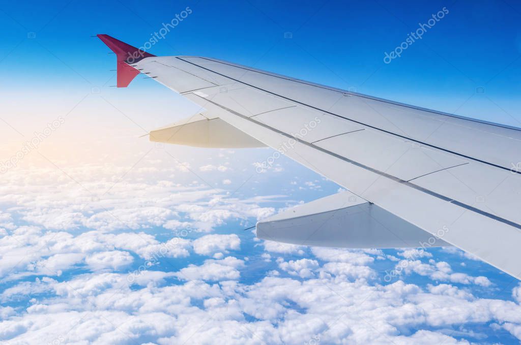 Wing of airplane in flight on a background of clouds. The concept of travel and flights to new countries
