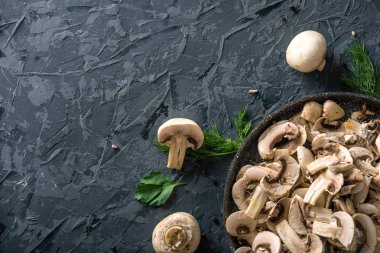 Bir tavada karanlık mutfak masasının üzerinde beyaz taze dilimlenmiş petrol. Mantar yemekleri pişirme kavramı. Yakın çekim