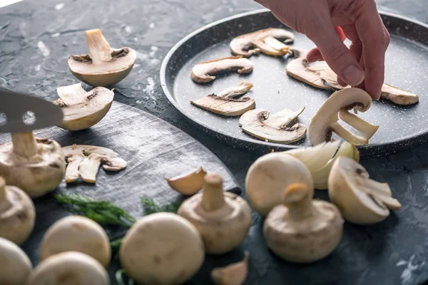 Vrouwelijke Hand Opbaren Van Gesneden Kampioenen Pan Donkere Keukentafel Het — Stockfoto