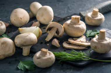 Taze beyaz Petrol bir bıçak ve karanlık mutfak masasında malzemeler ile ikiye böldüm. Mantar yemekleri pişirme kavramı. Yakın çekim