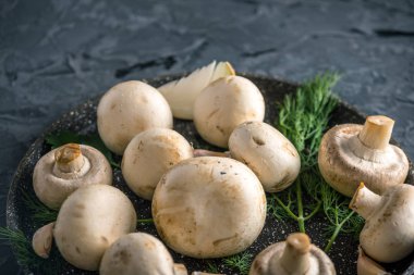 Pan ve malzemelerin karanlık mutfak masasının üzerine taze beyaz Şampiyonlar. Mantar yemekleri pişirme kavramı. Yakın çekim