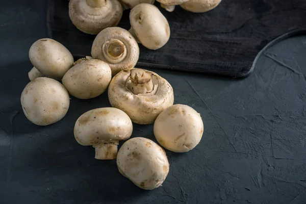 Taze beyaz Petrol karanlık mutfak masasının üzerinde. Mantar ile lezzetli yemekleri pişirme