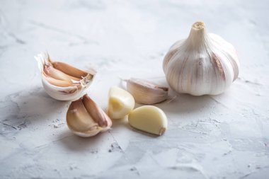 Beyaz zemin üzerinde bir tablo grubu sarimsak dağınık. Dünyanın farklı mutfaklarından önemli bir madde. Sağlıklı bir ürün.