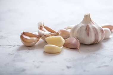 Beyaz zemin üzerinde bir tablo grubu sarimsak dağınık. Dünyanın farklı mutfaklarından önemli bir madde. Sağlıklı bir ürün.