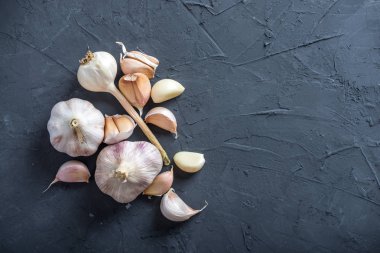 Beyaz zemin üzerinde bir tablo grubu sarimsak dağınık. Dünyanın farklı mutfaklarından önemli bir madde. Sağlıklı bir ürün.