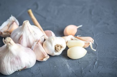 Beyaz zemin üzerinde bir tablo grubu sarimsak dağınık. Dünyanın farklı mutfaklarından önemli bir madde. Sağlıklı bir ürün.