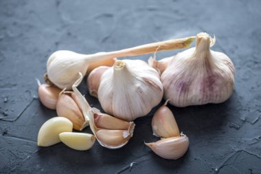 Beyaz zemin üzerinde bir tablo grubu sarimsak dağınık. Dünyanın farklı mutfaklarından önemli bir madde. Sağlıklı bir ürün.