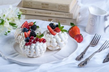 Hassas beyaz meringues plaka üzerinde taze çilek ile. Tatlı Pavlova. Beyaz arka plan. Şenlikli bir düğün pastası.