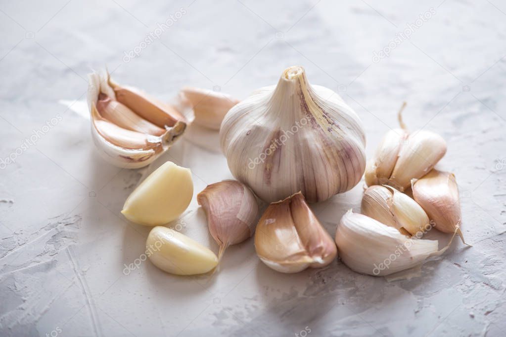 Group of garlic cloves scattered on a table on a white background. An important ingredient in different cuisines of the world. A healthy product.
