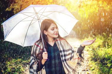 Mutlu genç kadın yağmur altında beyaz bir şemsiye ile Sunny Park'ta yürüyordunuz. Mevsim ve sonbahar ruh kavramı