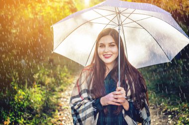 Mutlu genç kadın yağmur altında beyaz bir şemsiye ile Sunny Park'ta yürüyordunuz. Mevsim ve sonbahar ruh kavramı