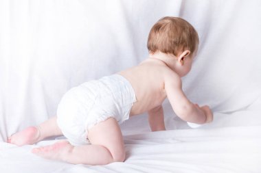 Şirin mavi gözlü bebek 6-9 ay gülümseyen ve beyaz arka plan üzerinde oynama. Çocuk duygular. Temizlik ve bakım bebekler için