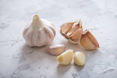 Beyaz zemin üzerinde bir tablo grubu sarimsak dağınık. Dünyanın farklı mutfaklarından önemli bir madde. Sağlıklı bir ürün.