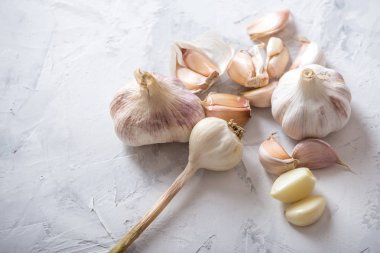 Beyaz zemin üzerinde bir tablo grubu sarimsak dağınık. Dünyanın farklı mutfaklarından önemli bir madde. Sağlıklı bir ürün.