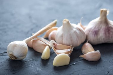 Beyaz zemin üzerinde bir tablo grubu sarimsak dağınık. Dünyanın farklı mutfaklarından önemli bir madde. Sağlıklı bir ürün.