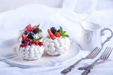 Hassas beyaz meringues plaka üzerinde taze çilek ile. Tatlı Pavlova. Beyaz arka plan. Şenlikli bir düğün pastası.