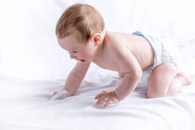 Şirin mavi gözlü bebek 6-9 ay gülümseyen ve beyaz arka plan üzerinde oynama. Çocuk duygular. Temizlik ve bakım bebekler için