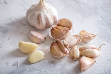 Beyaz zemin üzerinde bir tablo grubu sarimsak dağınık. Dünyanın farklı mutfaklarından önemli bir madde. Sağlıklı bir ürün.