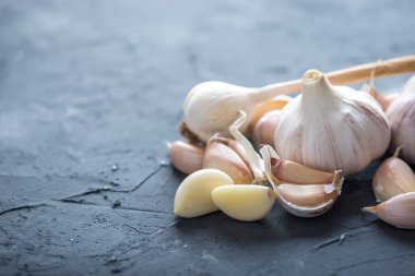Beyaz zemin üzerinde bir tablo grubu sarimsak dağınık. Dünyanın farklı mutfaklarından önemli bir madde. Sağlıklı bir ürün.