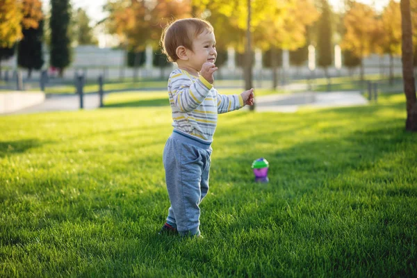 Kleiner Junge im grünen Hemd läuft und kurze Hosen, Kind i Kleiner Junge im grünen Hemd läuft und kurze Hosen, Kind i