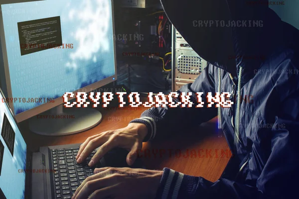 An anonymous hacker without a face is trying to steal cryptocurrency using a computer. Fraud and deception at Cryptojacking