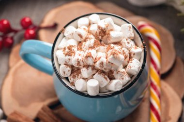 Bir fincan sıcak çikolata hatmi üstte ve ahşap arka plan üzerinde lolipop sopa ile. Sıcak sıcak kış rustik kompozisyon