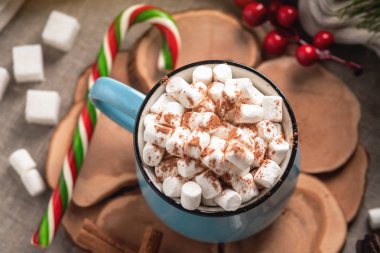 Bir fincan sıcak çikolata hatmi üstte ve ahşap arka plan üzerinde lolipop sopa ile. Rahat bir Noel ev tatil kavramı