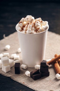 Bir fincan sıcak çikolata hatmi üstte ve koyu ahşap arka plan üzerinde lolipop sopa ile. Sıcak sıcak kış rustik kompozisyon