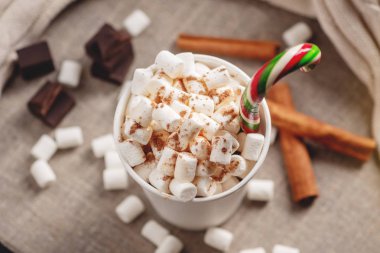 Bir bardak sıcak çikolata marshmallow üst ve arka planda çikolata ve tarçın bir lolipop sopa ile. Rahat bir Noel ev tatil kavramı