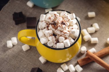 Bir bardak sıcak çikolata marshmallow üst ve arka planda çikolata ve tarçın bir lolipop sopa ile. Sıcak sıcak kış rustik ruh kompozisyon