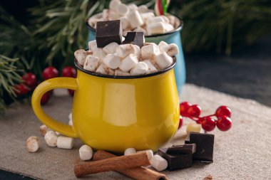 Kupalar ile hatmi üstte ve lolipop sıcak çikolata çikolata ve tarçın arka plan üzerinde sopa. Bir rahat sıcak Noel ev tatil kavramı