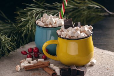 Kupalar ile hatmi üstte ve lolipop sıcak çikolata çikolata ve tarçın arka plan üzerinde sopa. Bir rahat sıcak Noel ev tatil kavramı