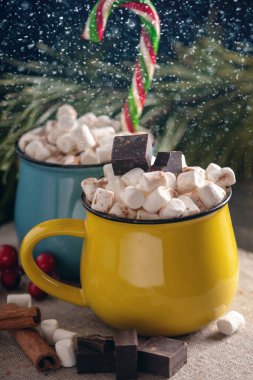 Kupalar ile hatmi üstte ve lolipop sıcak çikolata çikolata ve tarçın arka plan üzerinde sopa. Bir rahat sıcak Noel ev tatil kavramı