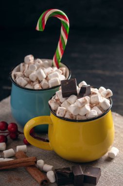 Kupalar ile hatmi üstte ve lolipop sıcak çikolata çikolata ve tarçın arka plan üzerinde sopa. Bir rahat sıcak Noel ev tatil kavramı