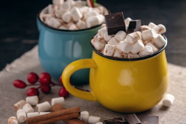 Bir fincan sıcak çikolata hatmi üstte ve koyu ahşap arka plan üzerinde lolipop sopa ile. Sıcak sıcak kış rustik kompozisyon